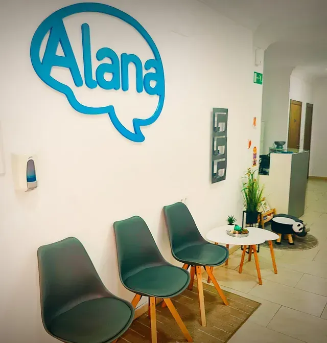 Una sala de espera con un logotipo azul de Alana en la pared.
